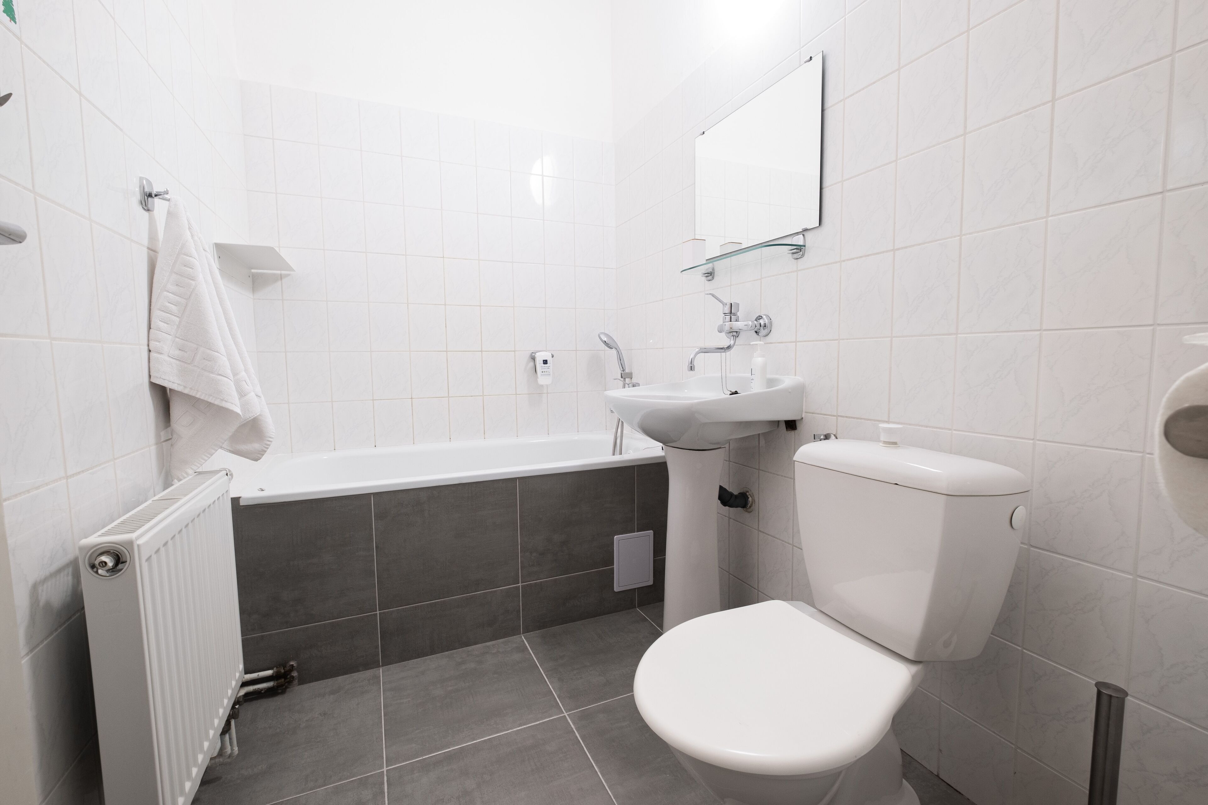 A modern bathroom with a bathtub, toilet, and sink.