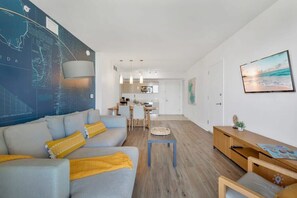 Una sala de estar moderna con sofá, mesa de centro y comedor con sillas y una mesa.