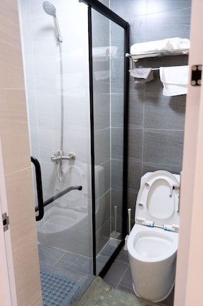 A modern bathroom with a glass-enclosed shower, a toilet, and a towel rack. - Monarch Condos – Upperhill (Nairobi)