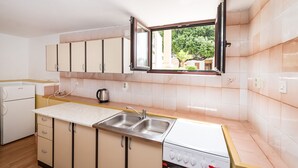 A kitchen with a window, a sink, a stove, and cabinets. - Apartment Ljubica With Nice Garden 2 (Novalja)