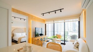 A modern hotel room with a bed, a TV, a dining area, and large windows offering a city view. - w* | Premium 1BR in San Francisco w/ Pool (Panamá)