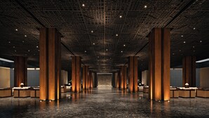 A spacious lobby with high ceilings, large wooden columns, and a polished marble floor. - The Meru Sanur (Denpasar)