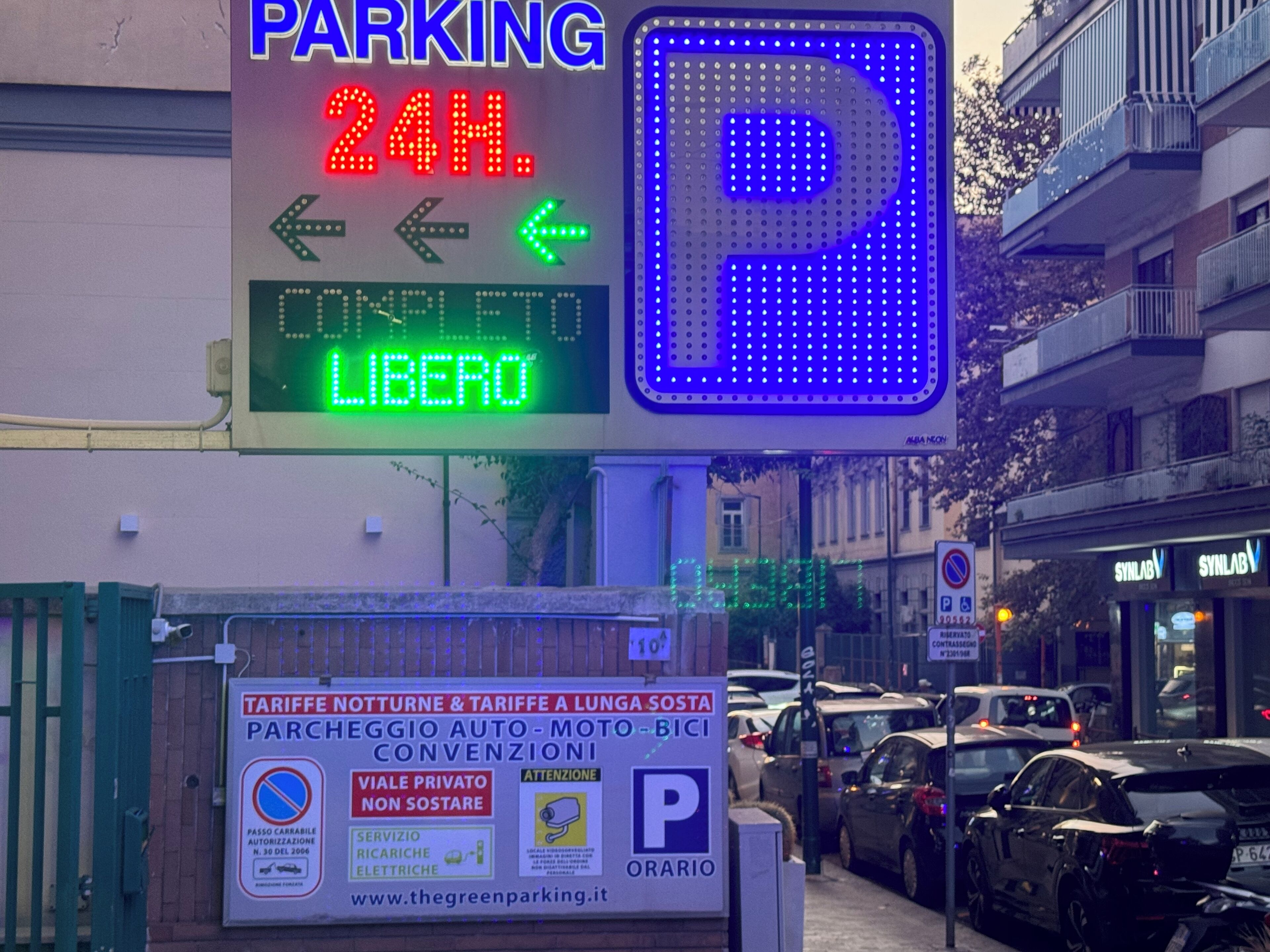 A parking sign with a 24-hour parking indication and a digital display for availability.