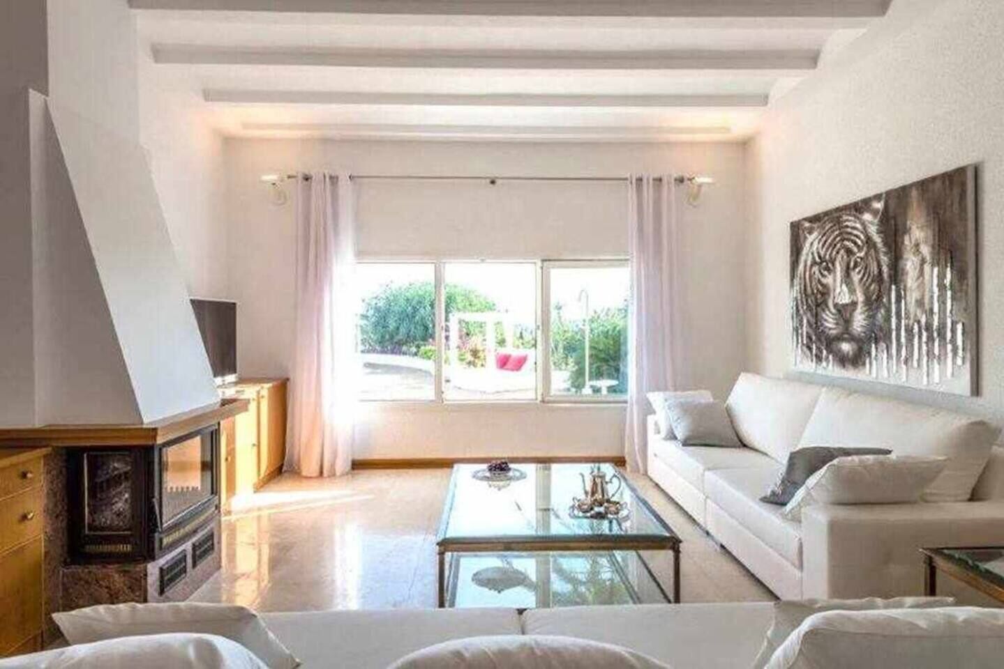 Una sala de estar moderna con sofá, mesa de centro y una obra de arte en la pared.