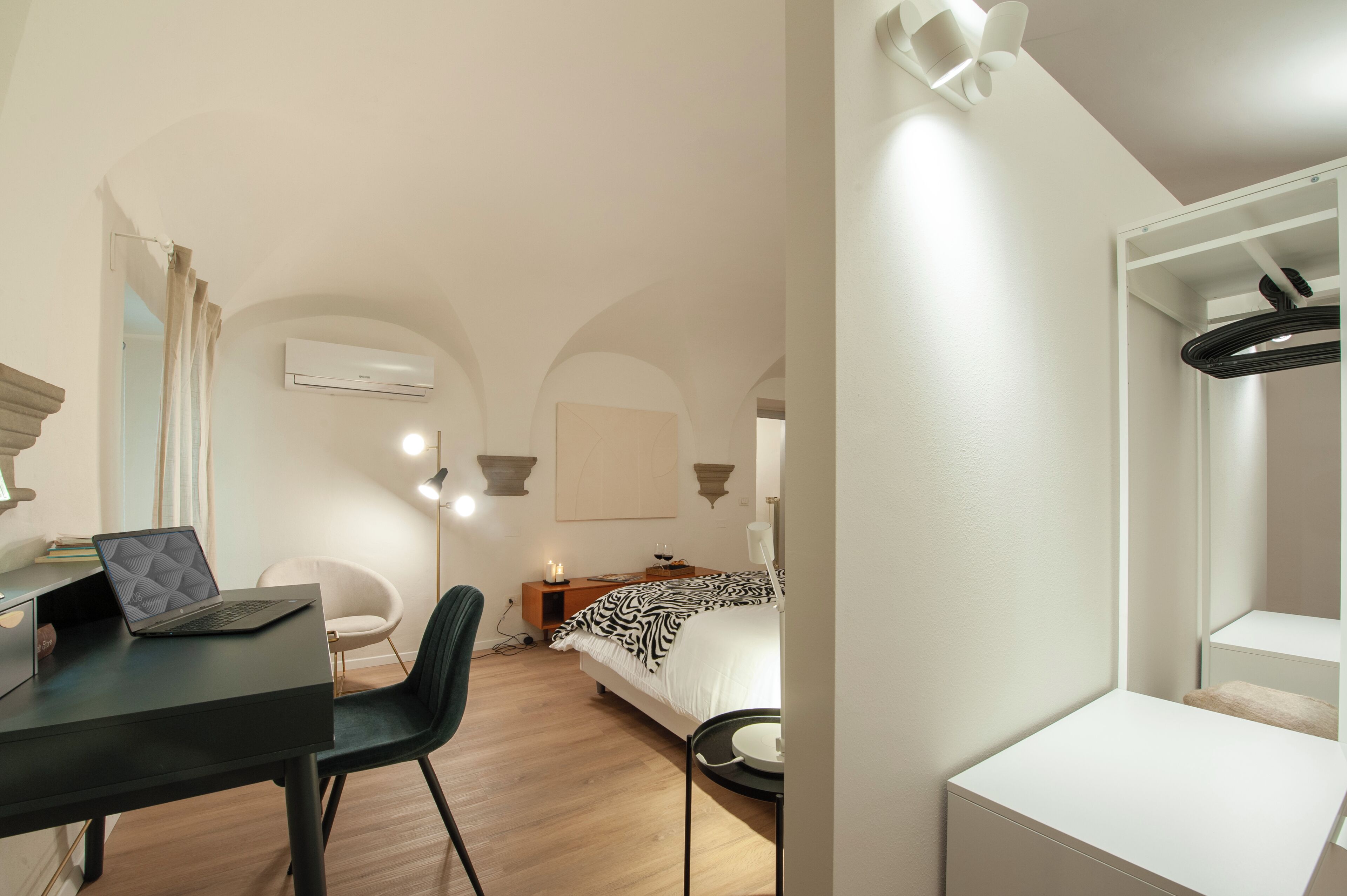 Et moderne hotelværelse med skrivebord, stol, seng og et lille bord.