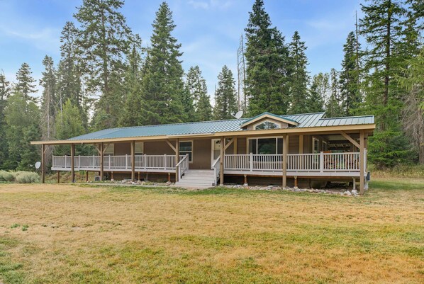 A two-story cabin with a covered porch and a satellite dish.