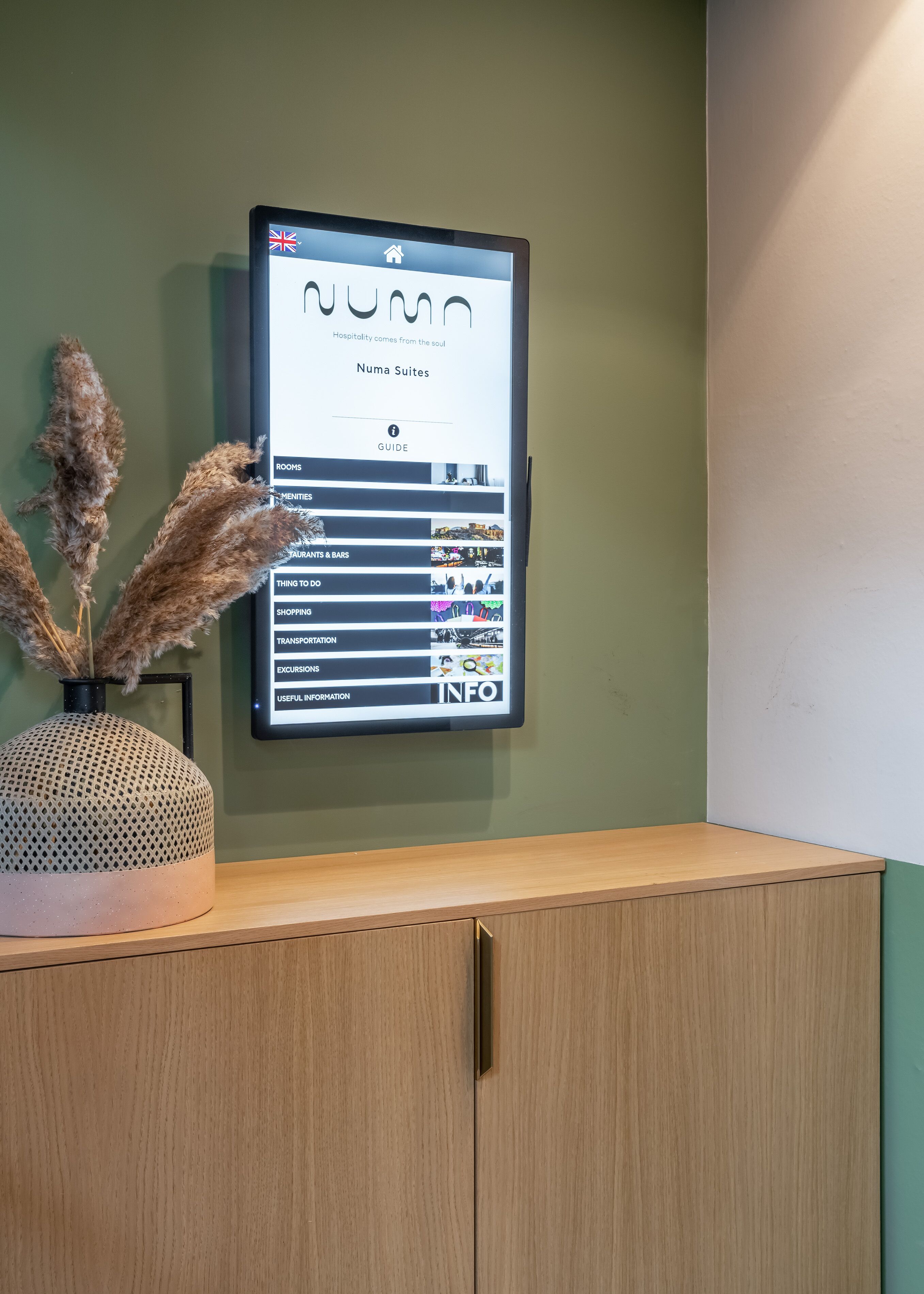 Ein digitales Anzeigetafel mit einer Auflistung der Hoteleinrichtungen, darunter Zimmer, Annehmlichkeiten, Restaurants und Bars, Aktivitäten, Einkaufsmöglichkeiten, Transport, Ausflüge und nützliche Informationen.