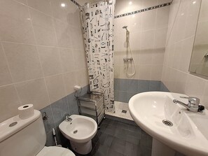 Kylpyhuone, jossa on bidee, wc, pesuallas ja suihku.