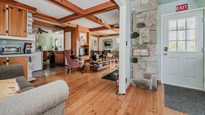 Ein geräumiger Wohnbereich mit Holzböden und einer Wand aus Stein.