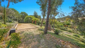 A backyard with a wooden deck, a small pond, and various trees. - Californie-piscine/CLiM/WiFi 12P (Carqueiranne)