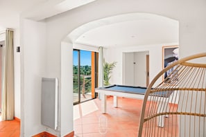 A modern room with a pool table, a large window, and a view of greenery. - Californie-piscine/CLiM/WiFi 12P (Carqueiranne)