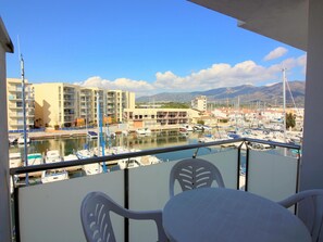 Ein Balkon mit Blick auf einen Yachthafen, Boote und Gebäude.