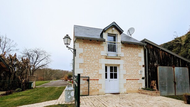 A stone building with a white door and a satellite dish.
