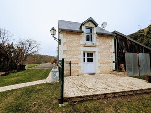 A stone building with a white door and a satellite dish.
