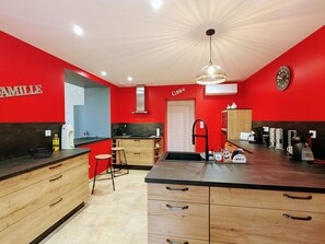 Een koelkast, een magnetron, een vaatwasser, eettafels