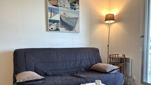 Ein modernes Wohnzimmer mit einem dunkelgrauen Sofa, einem weißen Couchtisch und einer Stehlampe.