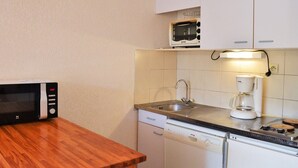 Una cocina compacta equipada con microondas, tostadora, cafetera y lavavajillas.