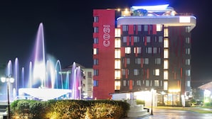A hotel with a red facade and a fountain in the foreground. - COSI Vientiane Nam Phu (Vientiane)