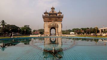 A large, ornate gateway with a central arch and multiple domes, surrounded by a reflective water surface.