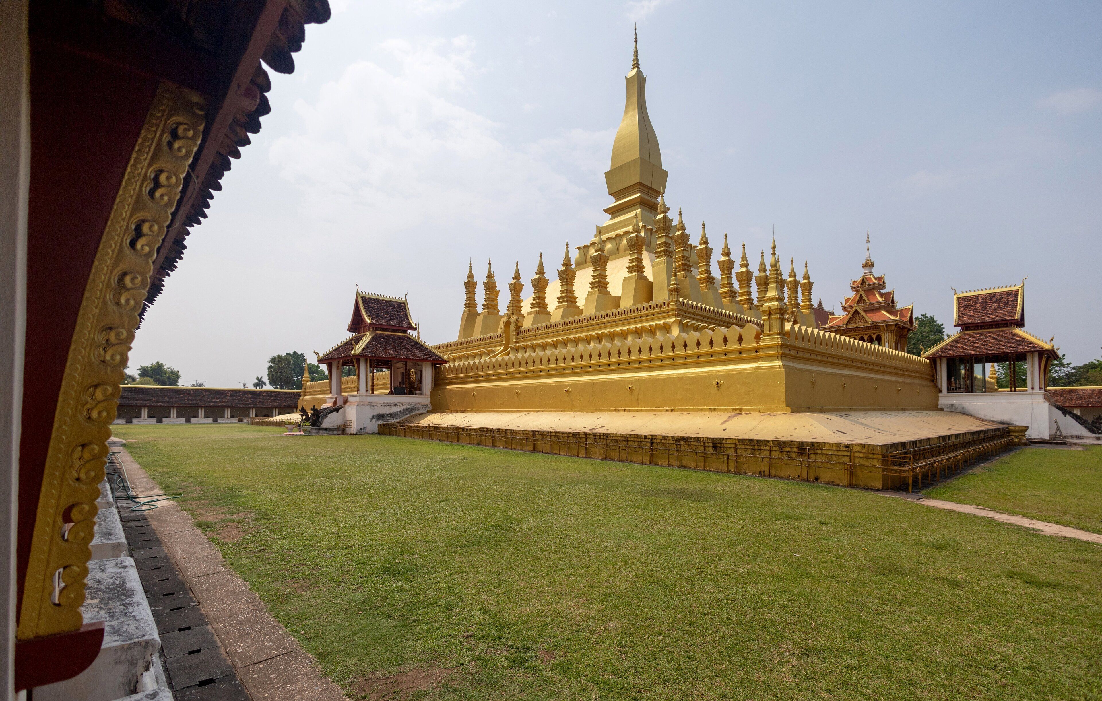 Un vaste complexe de temples dorés, doté de nombreuses flèches et d’un bâtiment principal central, le tout étant entouré d’une pelouse bien entretenue.