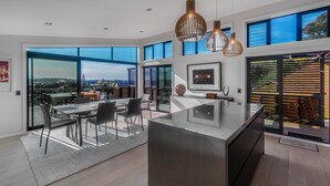 Una cocina moderna con una isla grande, ventanas amplias e iluminación colgante.