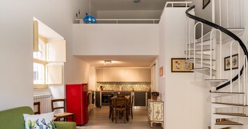Un interior moderno con comedor, cocina y escalera.