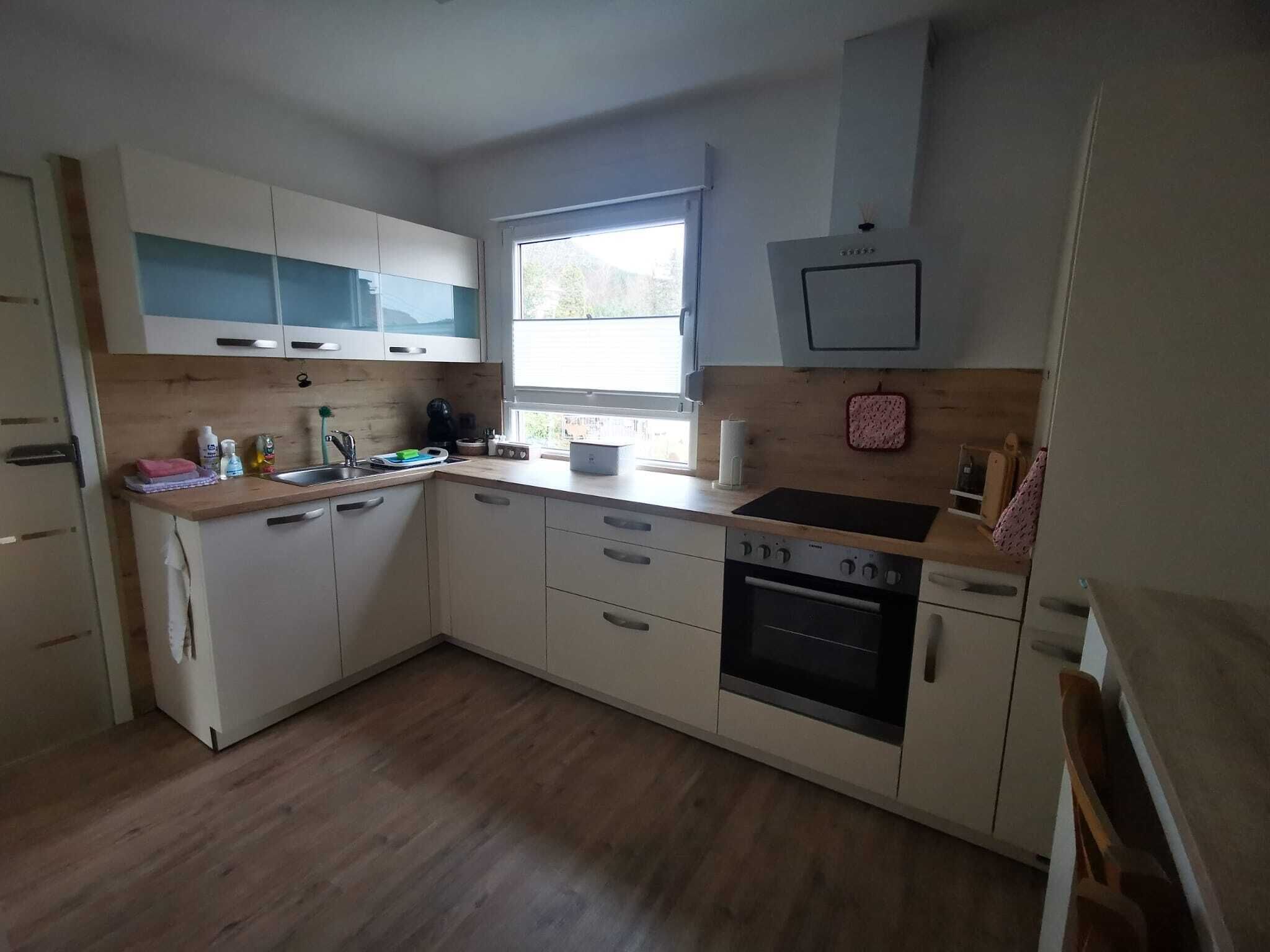 Eine moderne Küche mit Holdekor, einem eingebauten Backofen und einem Fenster für natürliches Licht.
