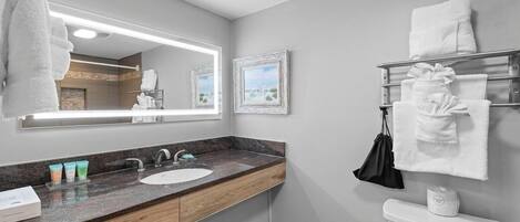 A bathroom with a sink, mirror, towel rack, and toilet.