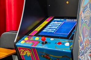 Una máquina de videojuegos con botones de colores y una pantalla mostrando opciones de juego.
