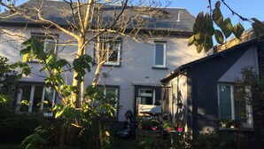 Een huis met twee verdiepingen en een tuin ervoor.