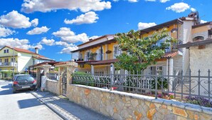 A residential street with houses, a stone wall, and a parked car. - Holiday apartment with air conditioning (Rovinj)