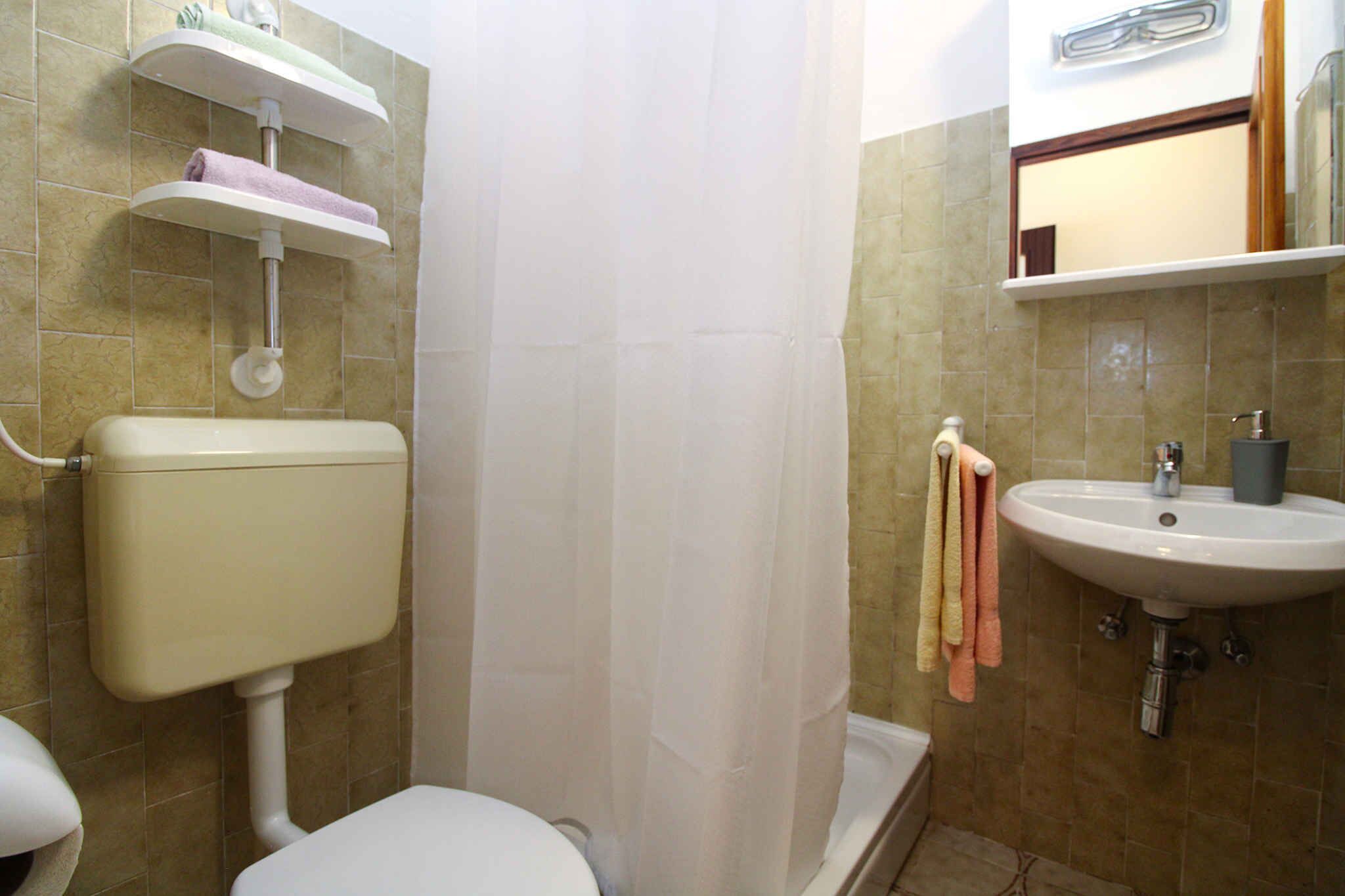 Ein Badezimmer mit Toilette, Waschbecken, Duschvorhang und Handtuchhalter.