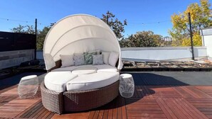 A round outdoor seating area with a canopy, wicker furniture, and a view of the surrounding landscape. - Rice Village Retreat - Rooftop deck & BBQ grill (Houston)