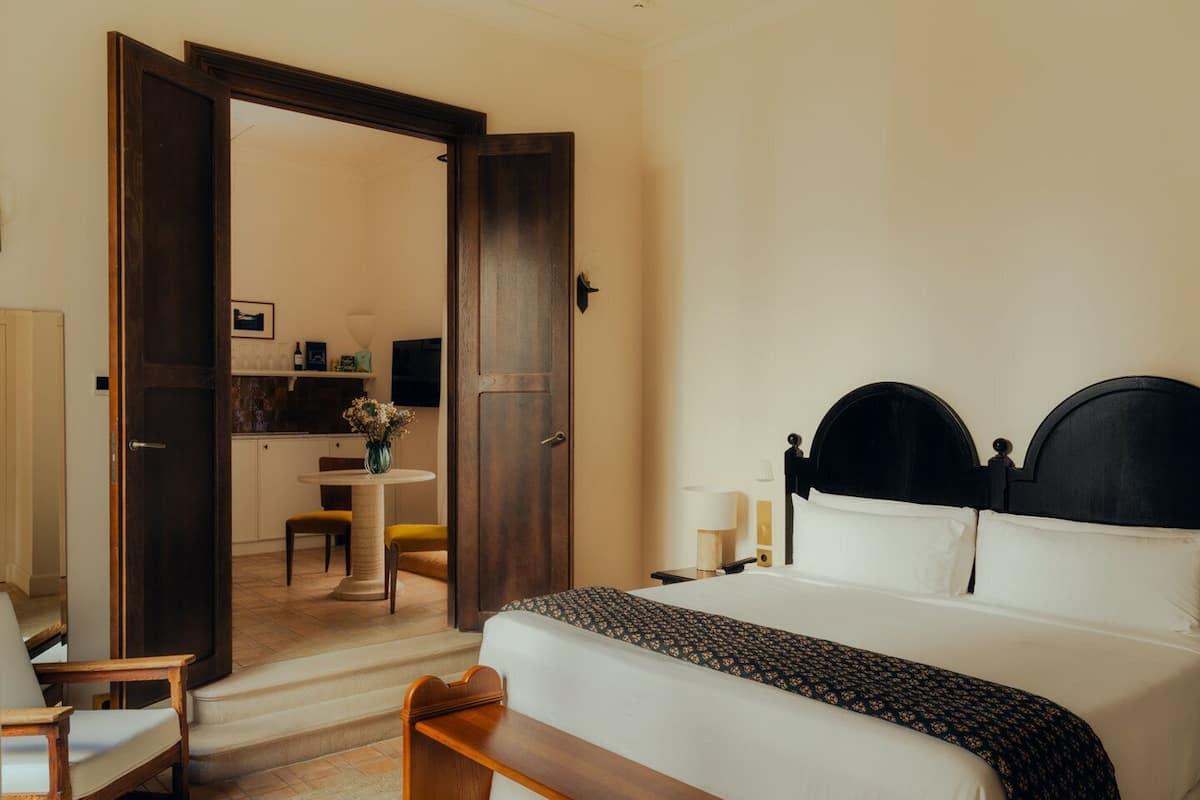 Ein Hotelzimmer mit Bett, Schreibtisch, Stuhl und einem kleinen Tisch.