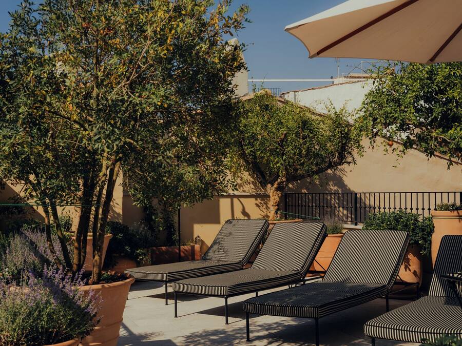 Un patio con sillones de descanso y una sombrilla grande.