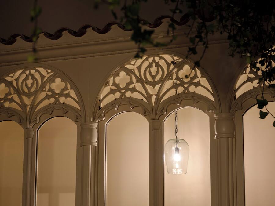 Una habitación con techos ornamentales en arco y un candelabro colgante.