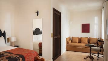 Une chambre d’hôtel avec un lit, un canapé, une petite table et une chaise.