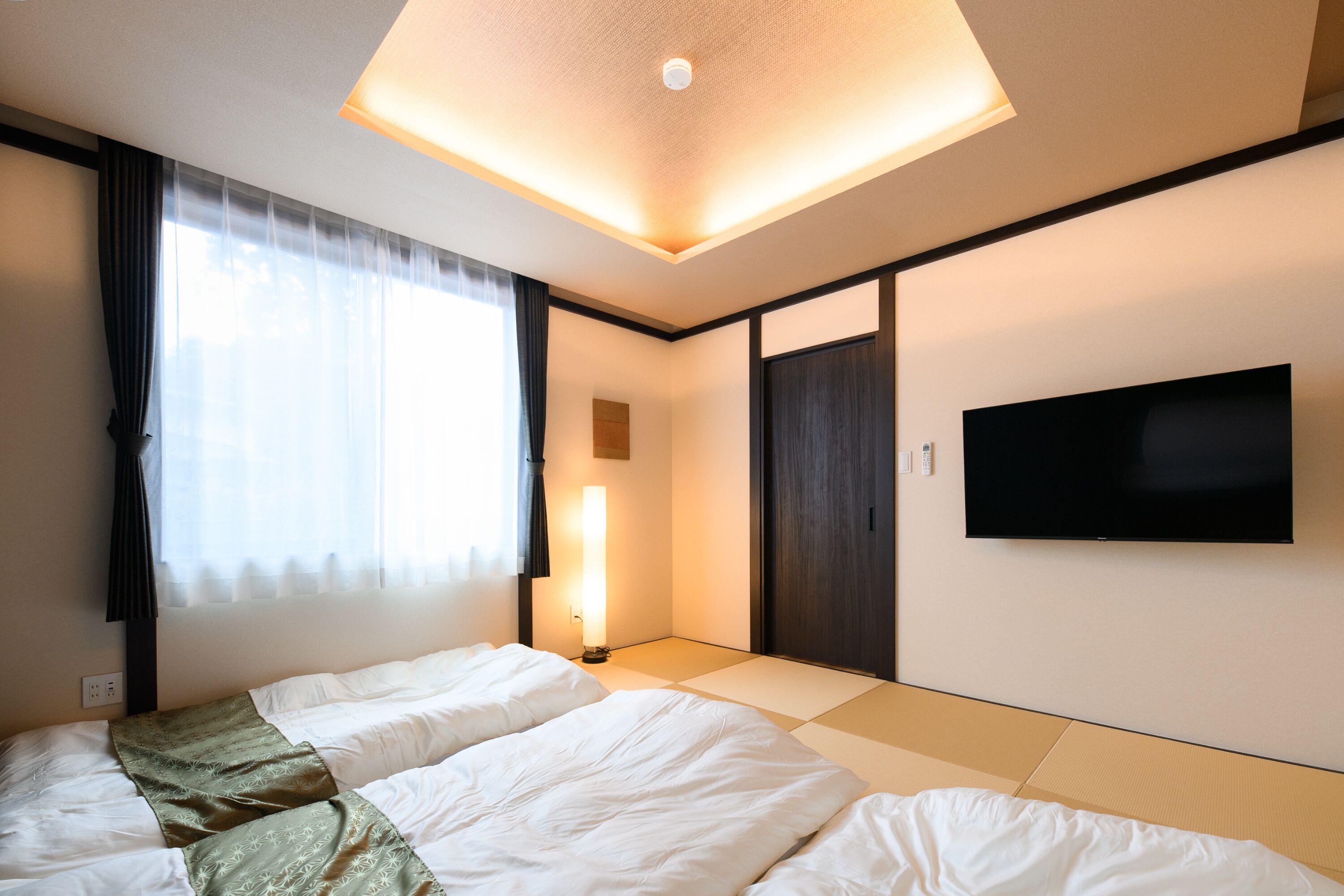 Une chambre d’hôtel avec un lit, une télévision et une porte coulissante.