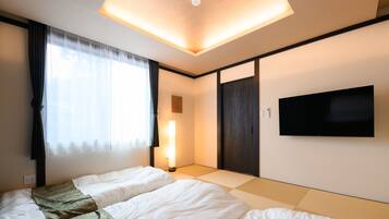 A hotel room with a bed, a TV, and a sliding door.