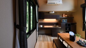 Una cocina compacta con piso de madera, una mesa de comedor y un horno empotrado.