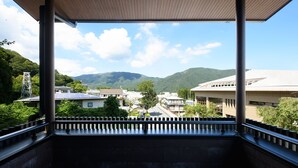 Un balcón con vistas a un área residencial, que incluye casas y montañas.