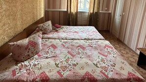 A bedroom with a bed, curtains, a window, and a ceiling fan. - Zhenja and Lyuda's Boarding House (Zhabagly)