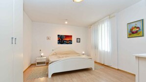 A bedroom with a bed, bedside tables, a rug, and wall art.