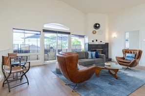 A spacious living room with a large glass door leading to an outdoor area, a sofa, two leather armchairs, and a coffee table. - Sunset Serenity On The Cliffs | Balcony| Oceanview (San Diego)