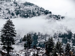 A mountainous landscape with snow-covered trees and houses. - The Voyage Resort, Manali (Manali)