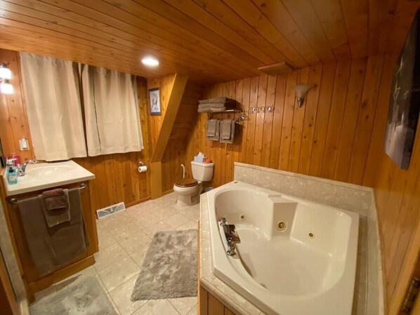 A wooden cabin bathroom with a sink, toilet, and bathtub. - U.P Norse A-frame ~ Your Adventure Basecamp! (Bessemer)
