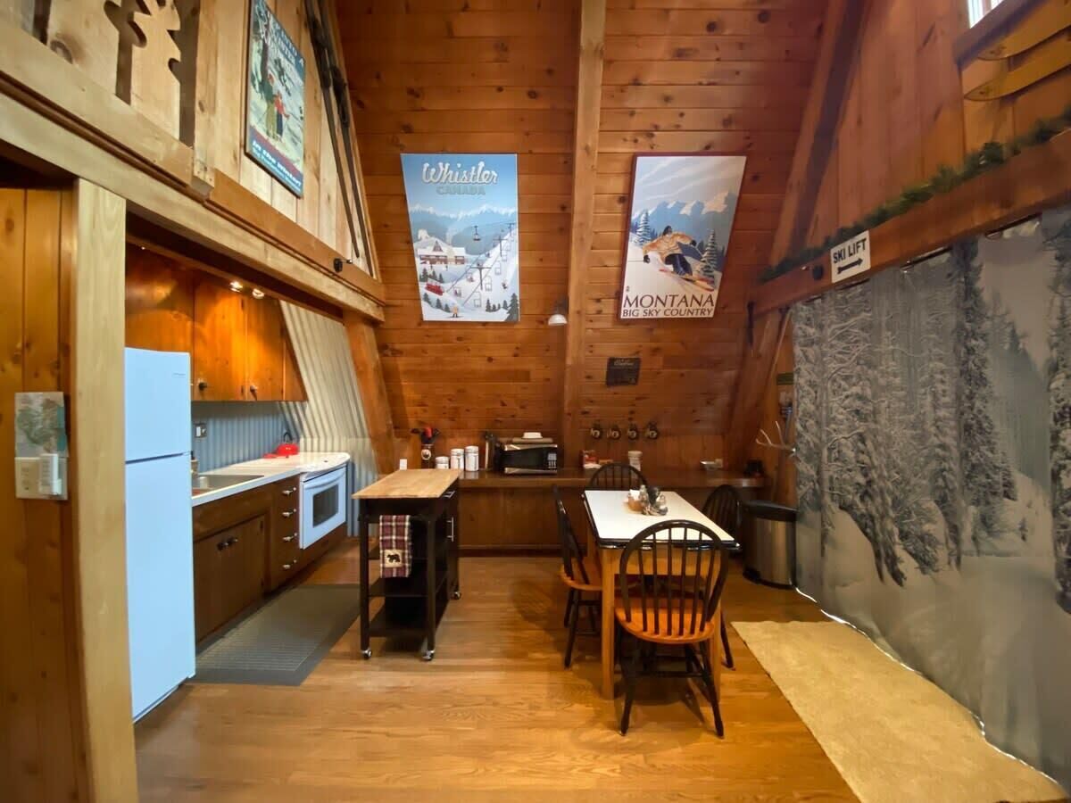 Interior de madera con cocina, comedor y un cartel de telesilla.