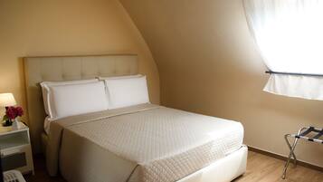 Une chambre à coucher avec un lit, une table de chevet et une fenêtre avec des rideaux.
