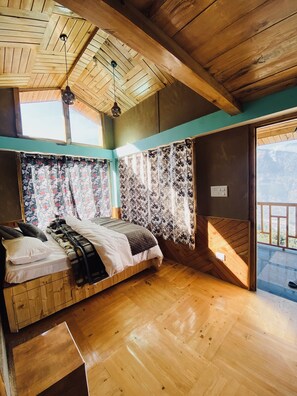 Relax in this inviting room with a plush bed, floral curtains, and a balcony view.