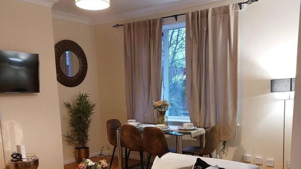 Een woonkamer met een bank, salontafel en een eethoek met stoelen en een tafel.